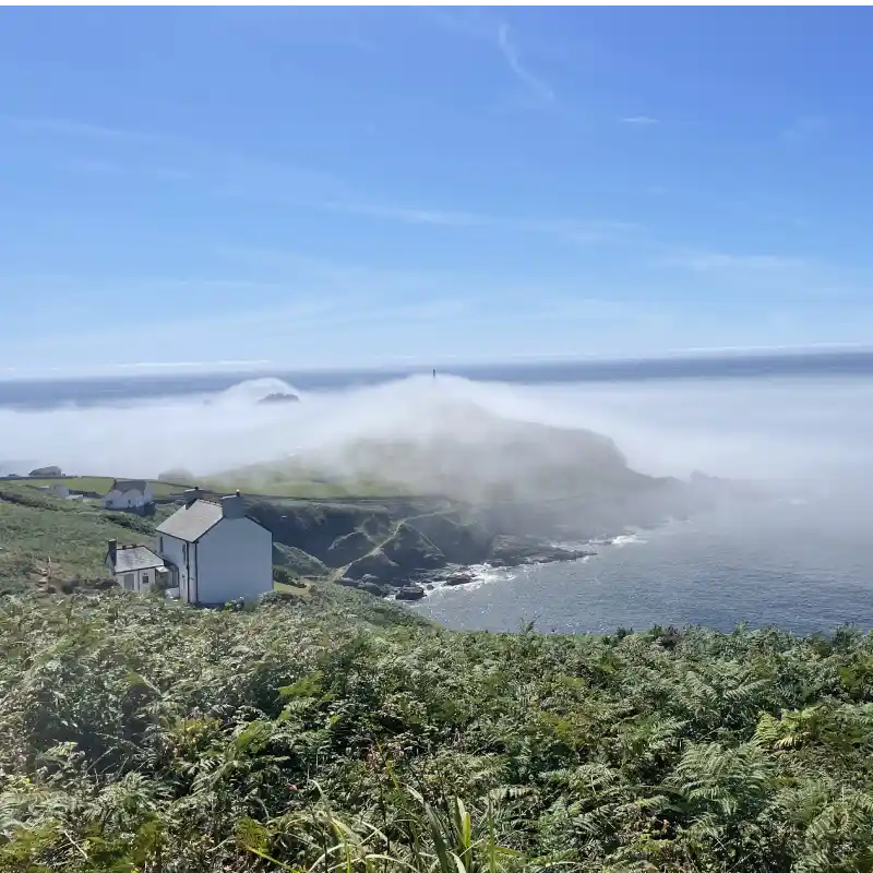 Atmospheric photo of Wheal Call holiday cottage retreat with sea mist over Cape Cornwall and The Brisons